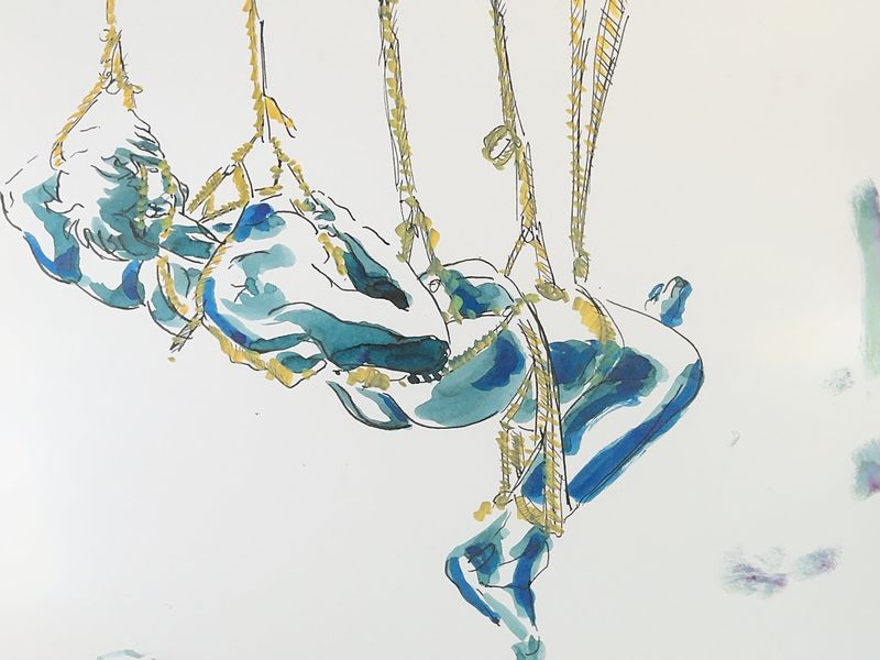 Model suspended in colorful rope bondage