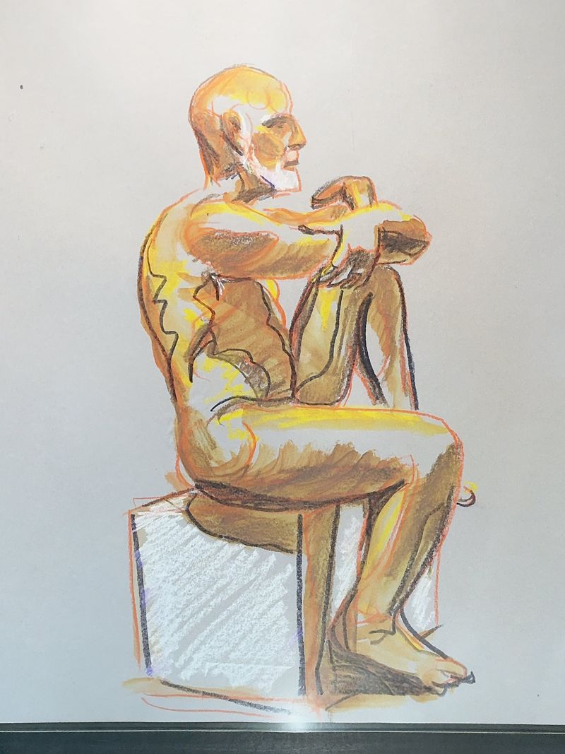 Model seated on pedestal with knee up